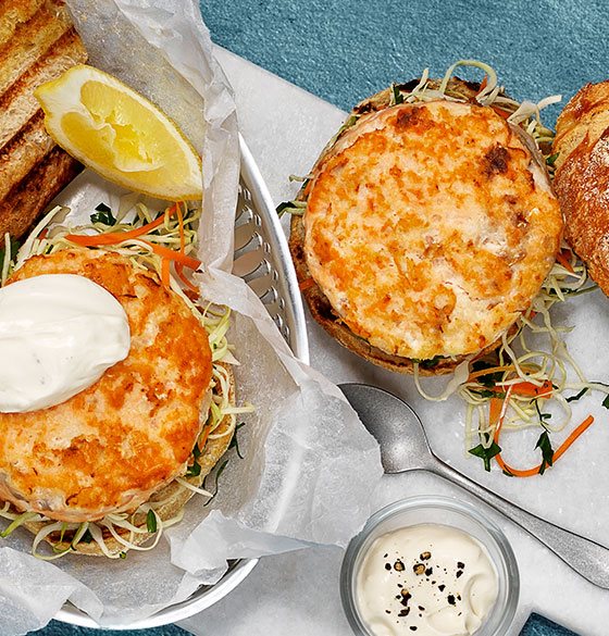 Fiskekaker, eller fiskeburger, med hvitløksdressing og råkost. Servert i surdeigsbrød, rundstykke eller hamburgerbrød