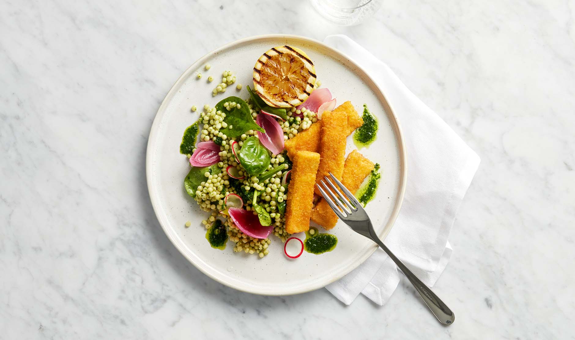 Fiskepinner med perlecouscous, urteolje og sitronstekt asparges