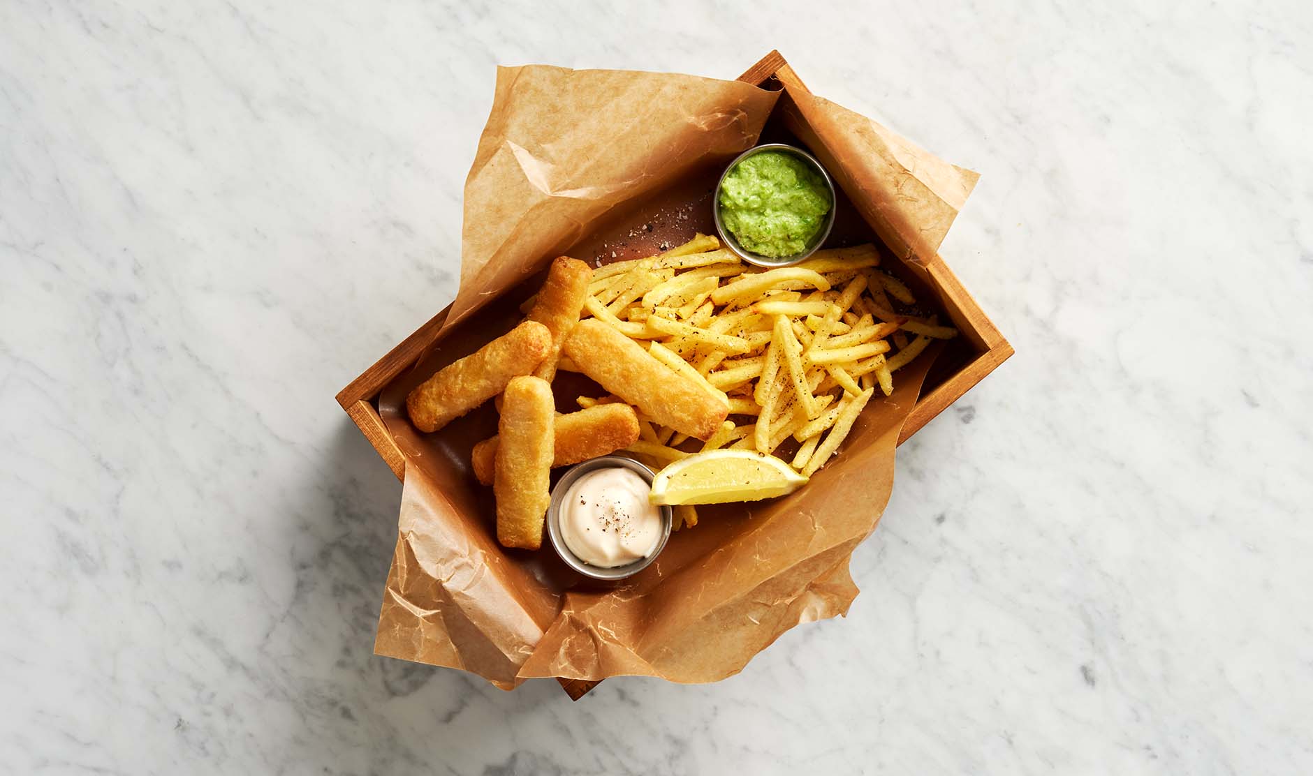 Fish & Crisp fiskepinner med pommes frites, ertehummus og citron