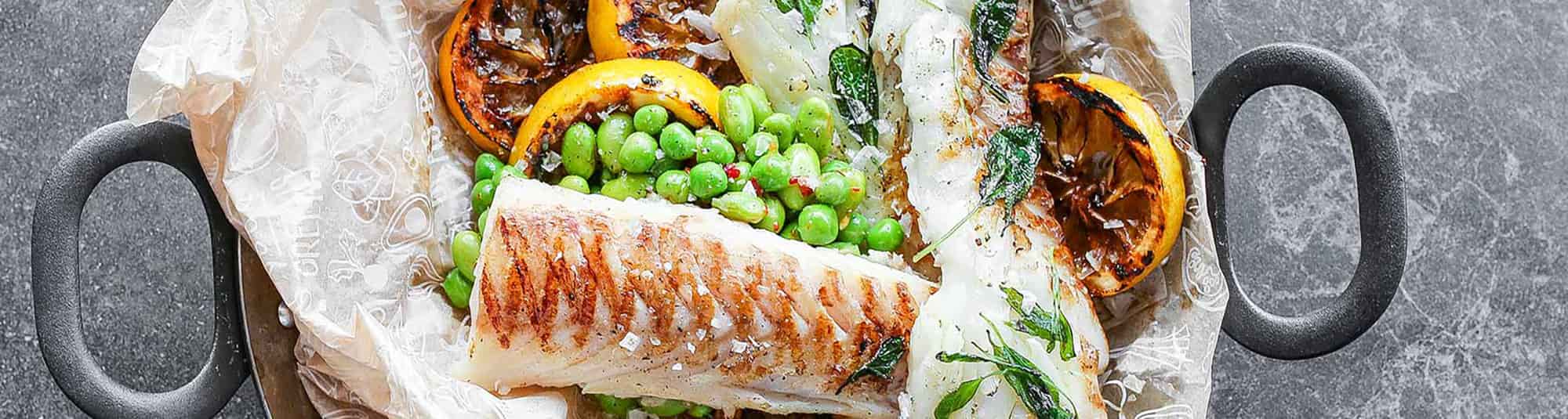 Lun erte- og bønnesalat servert med grillet torsk og sitron