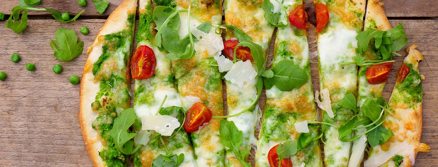 Grønn pizza med ertekrem, tomater, ruccola og parmesan